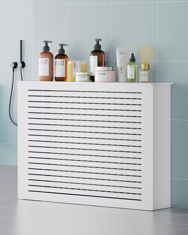 White radiator cover with horizontal slats and a flat top used for bathroom storage.