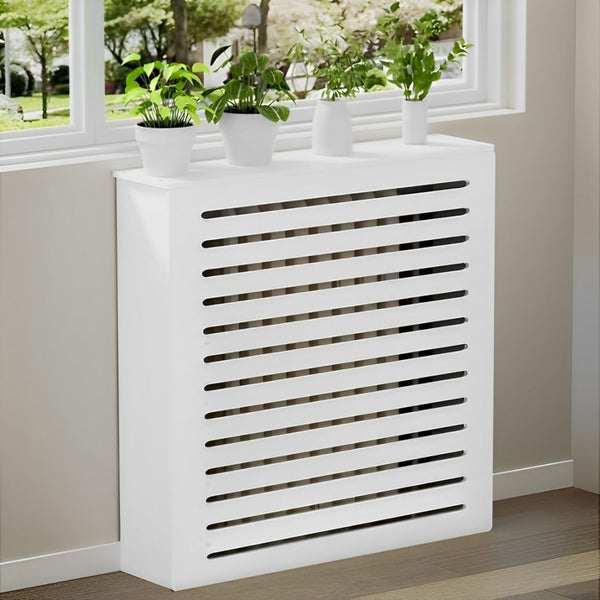 White radiator cover with slatted design in a room with a window and plants.