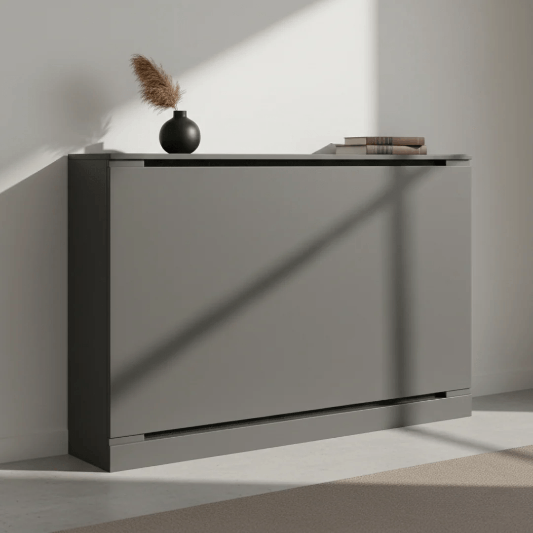Gray sideboard with a vase and books in a minimalistic room.